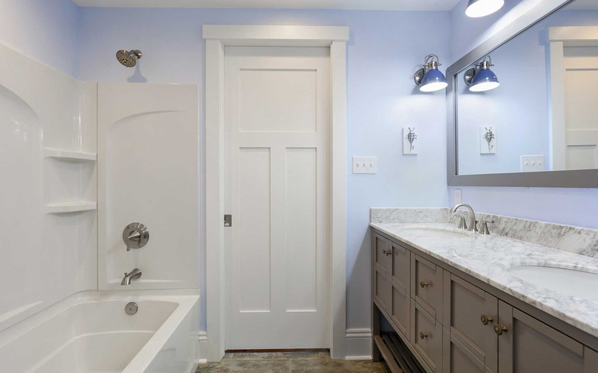 A bathroom with a tub , sink , mirror and shower.