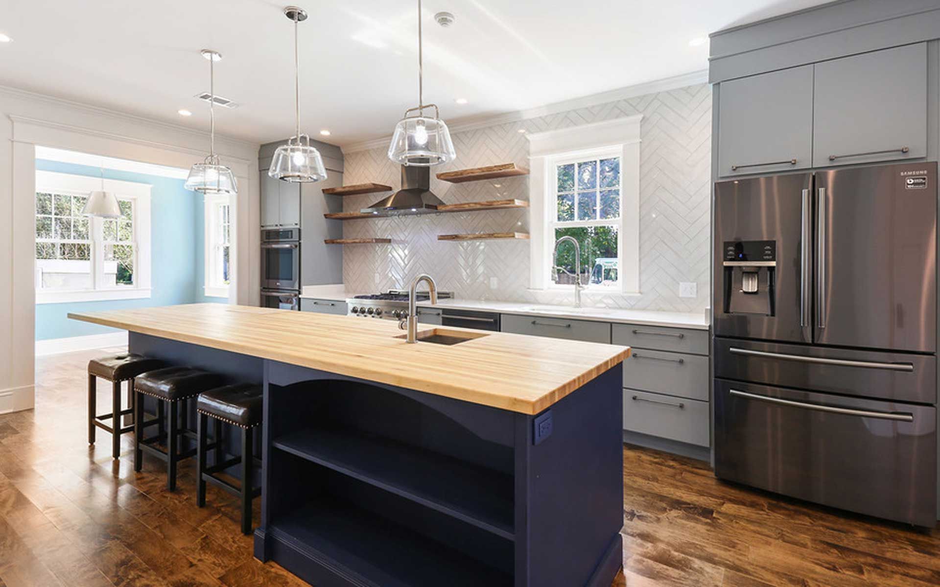 A kitchen with stainless steel appliances and a large island.