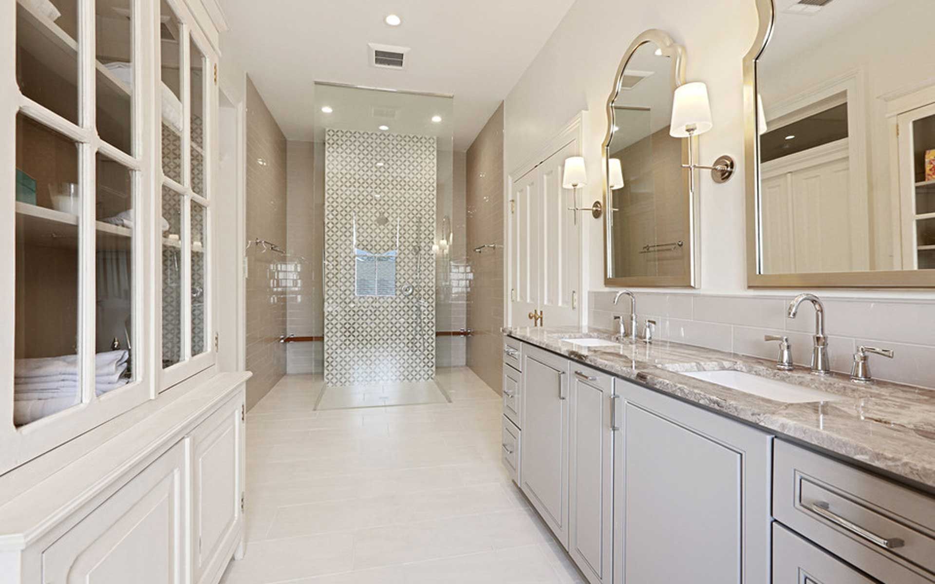 A bathroom with two sinks and a walk in shower.