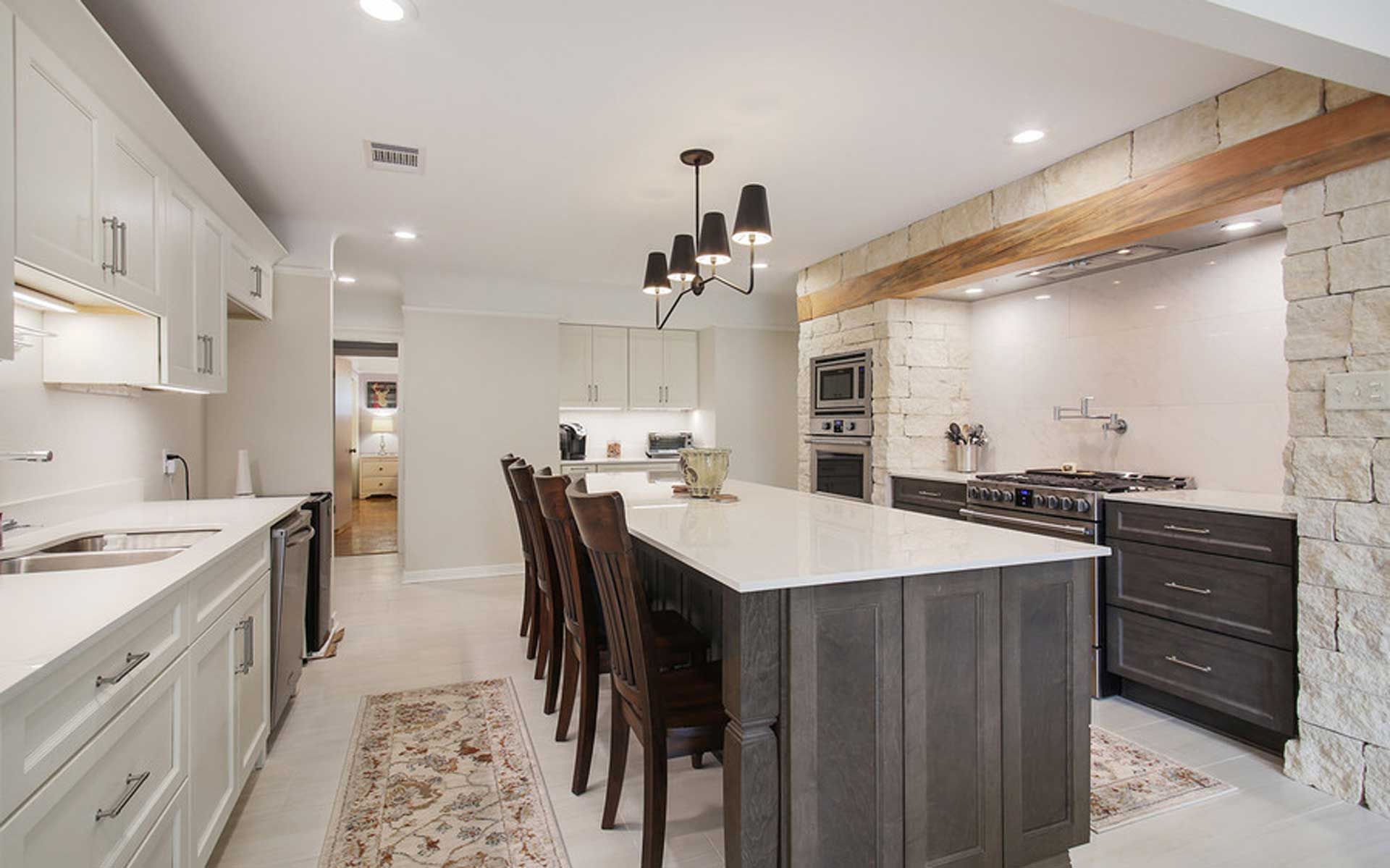 A kitchen with white cabinets and a large island in the middle.