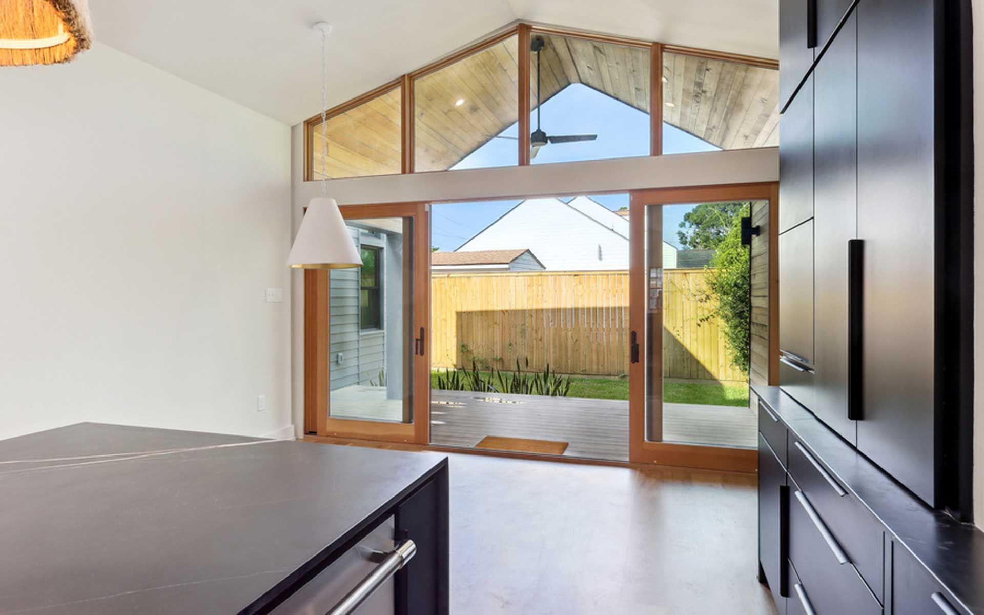 A kitchen with sliding glass doors leading to a backyard.