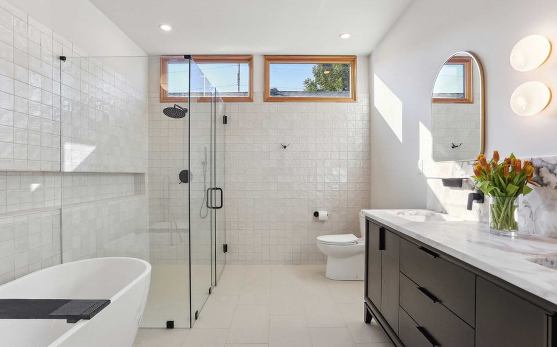 A bathroom with a bathtub , toilet , sink and shower.