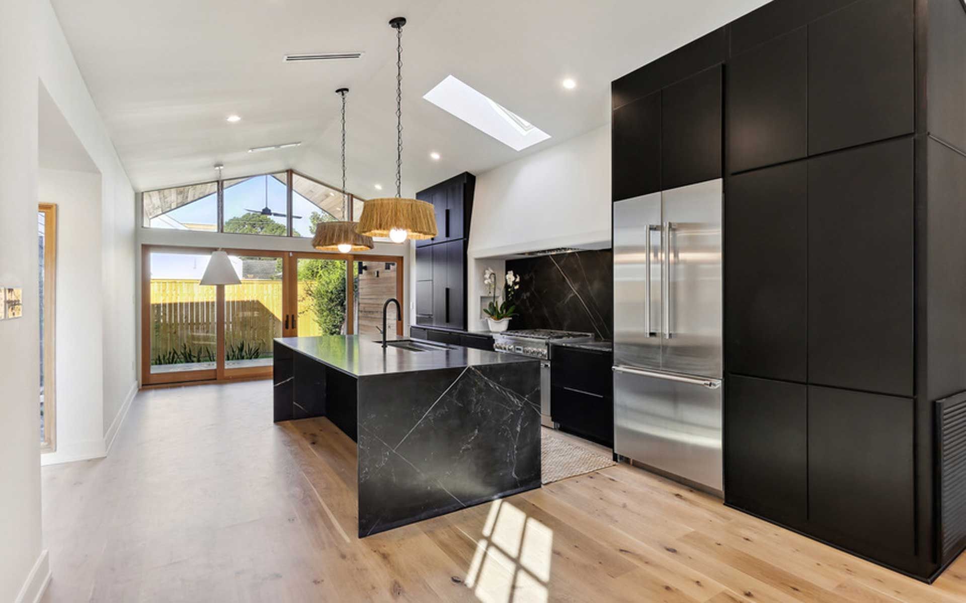 A kitchen with a large island and stainless steel appliances.