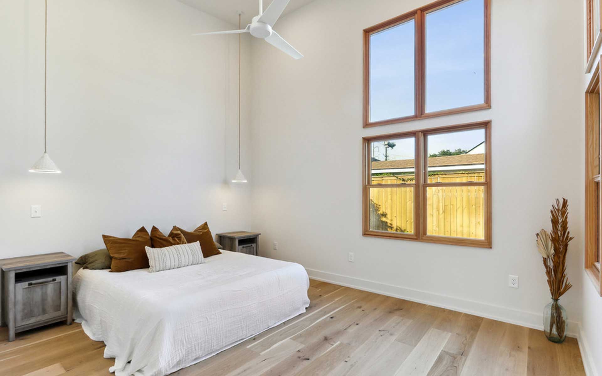 A bedroom with a bed , nightstands , and a ceiling fan.