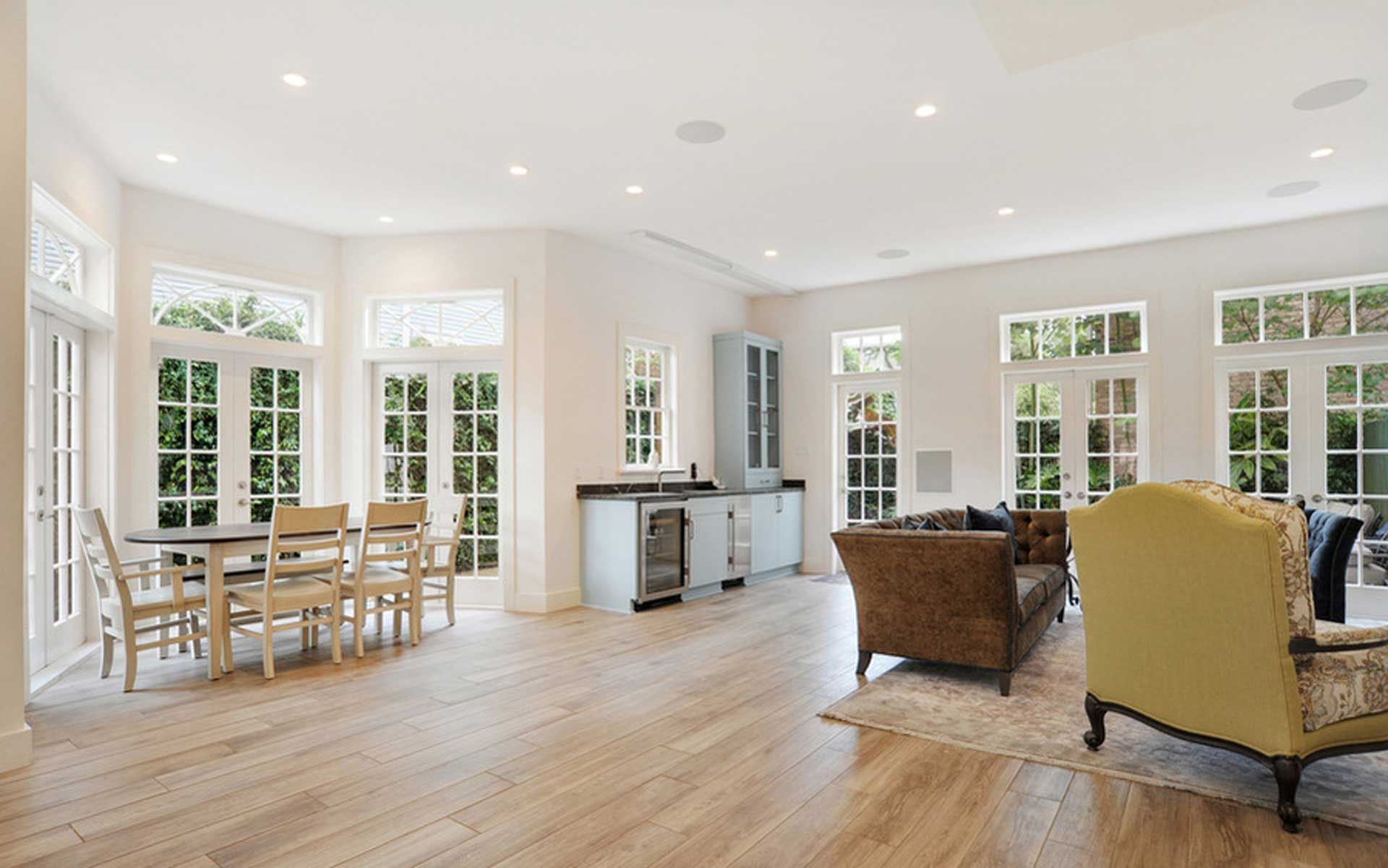 A living room with hardwood floors , a couch , chairs , and a table.