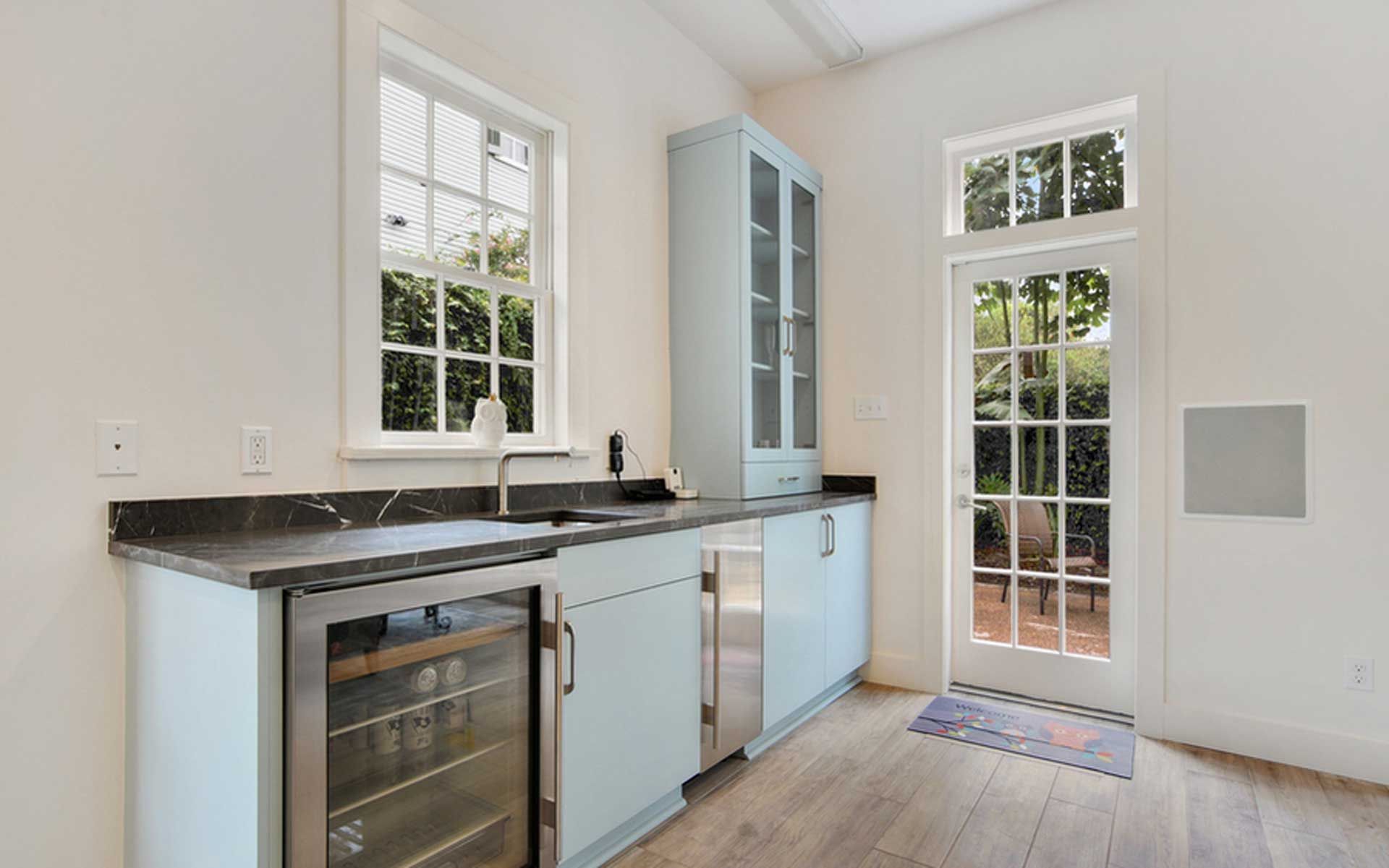 A kitchen with a sink , refrigerator , and stainless steel appliances.