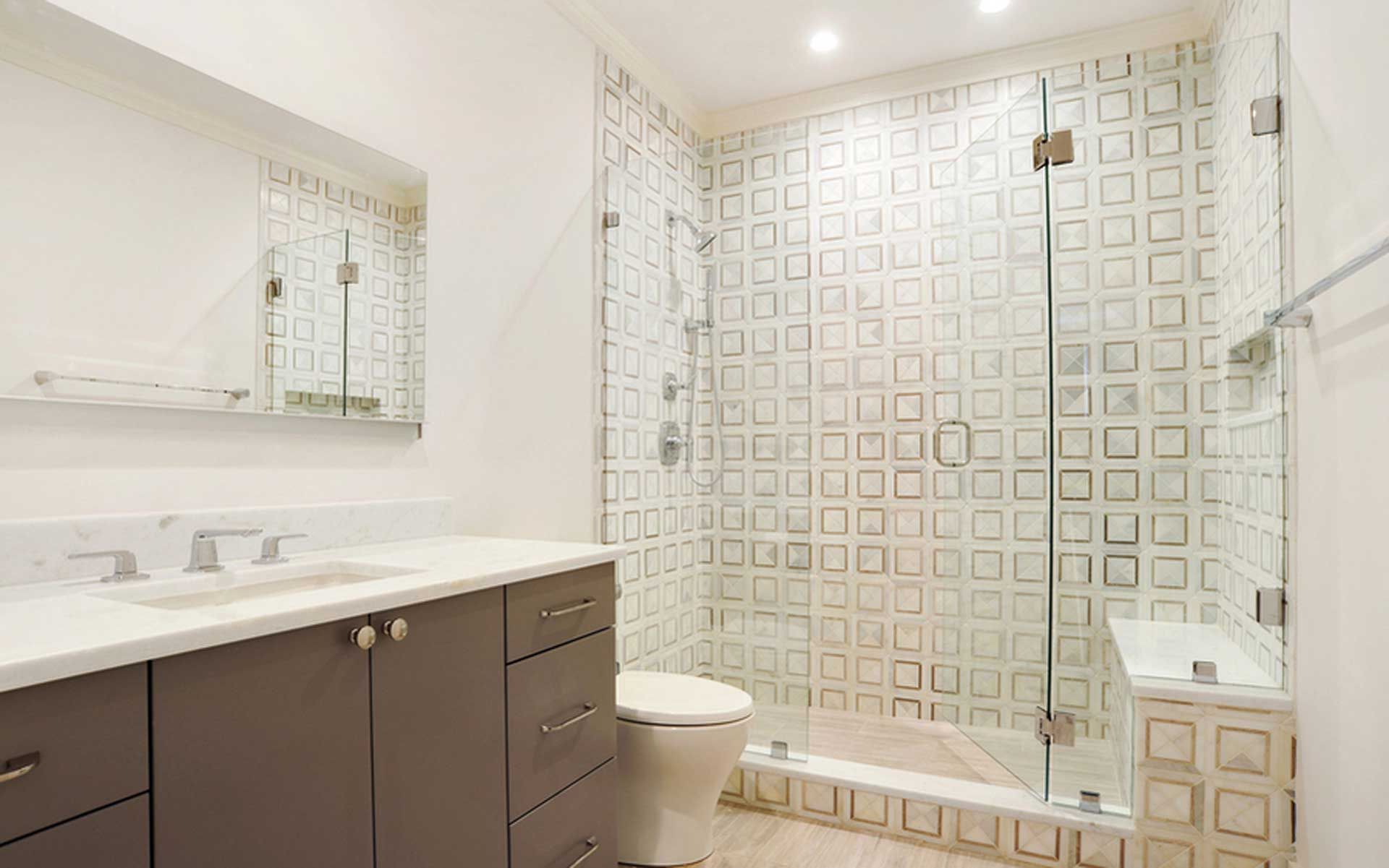 A bathroom with a toilet , sink , mirror and walk in shower.