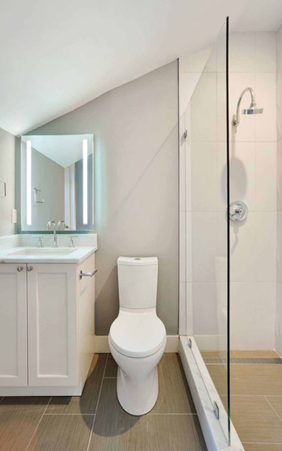 A bathroom with a toilet , sink , mirror and shower.