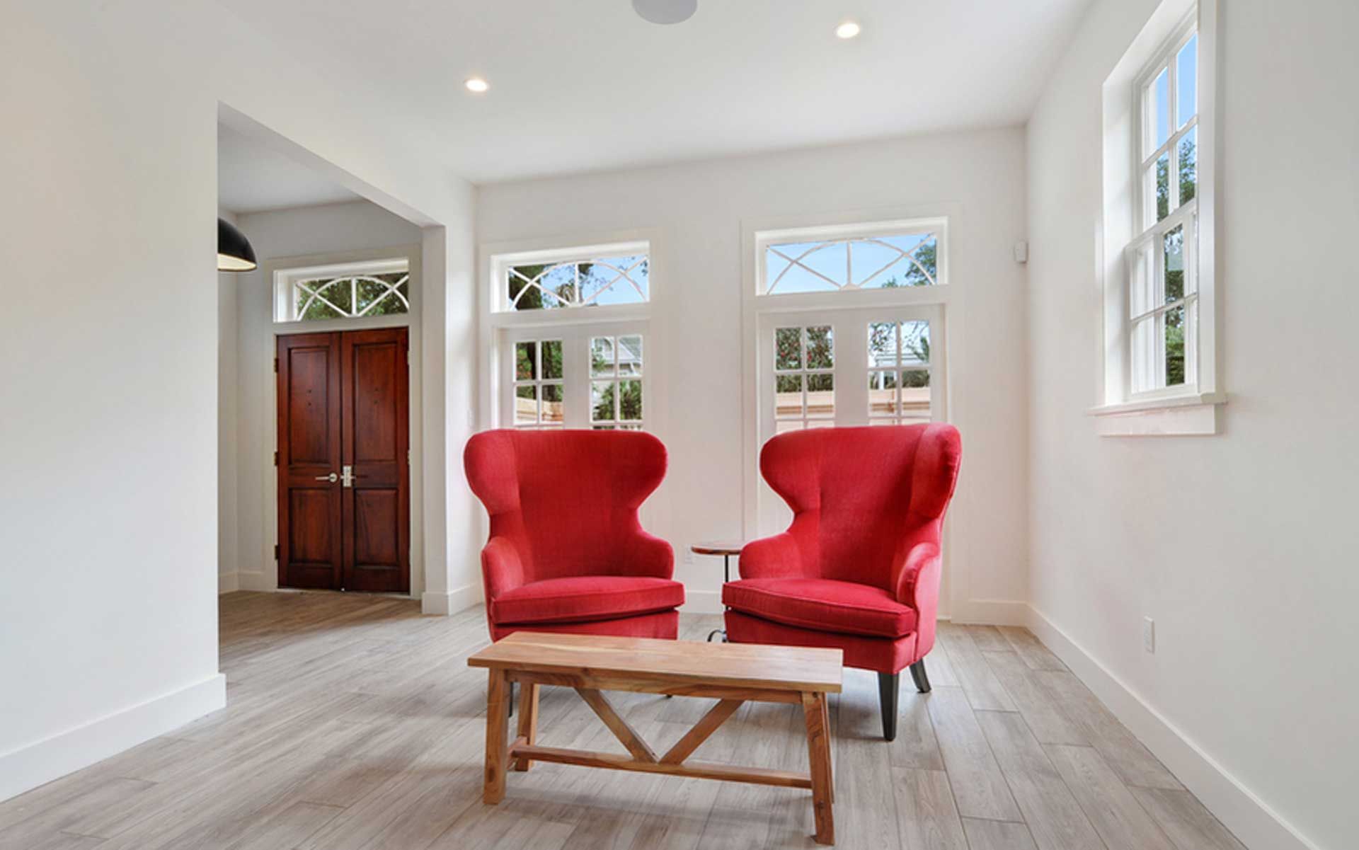 A living room with two red chairs and a coffee table