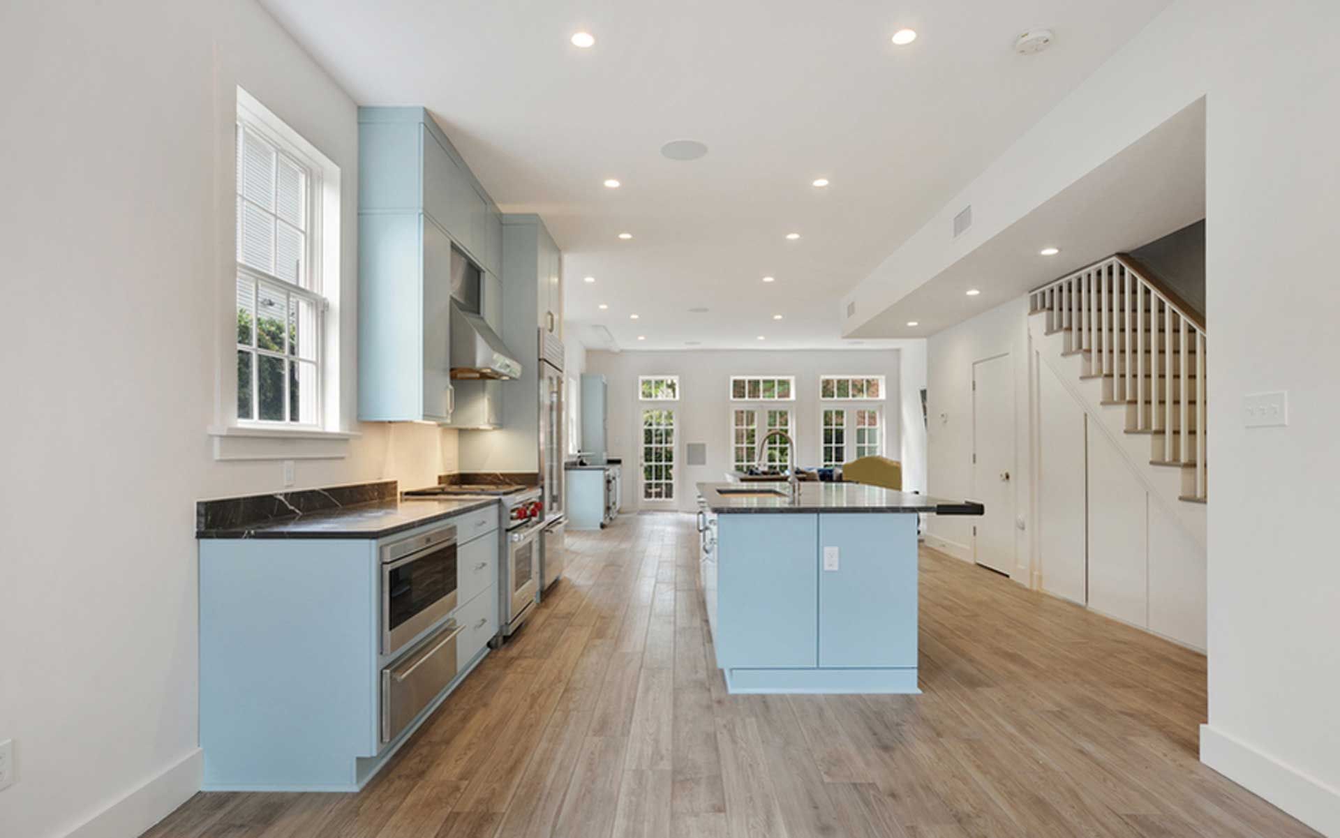 A kitchen in a house with blue cabinets and stainless steel appliances.