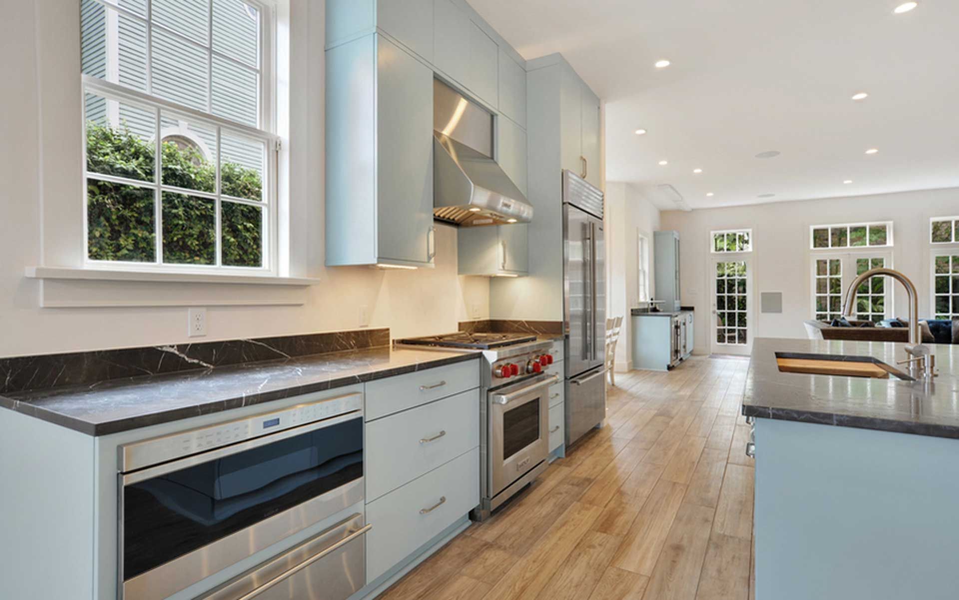 A kitchen with stainless steel appliances and blue cabinets.