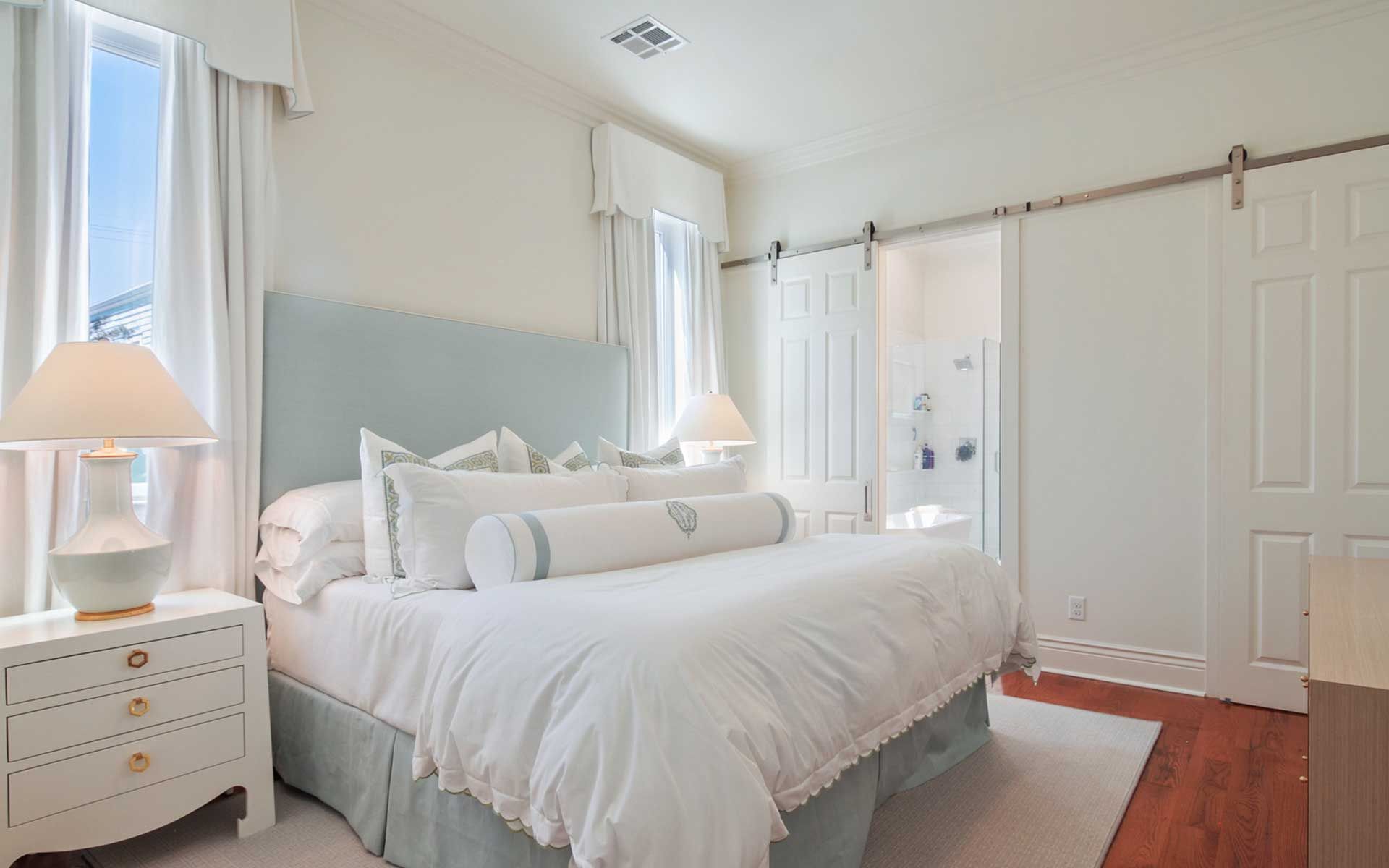 A bedroom with a king size bed and sliding barn doors.
