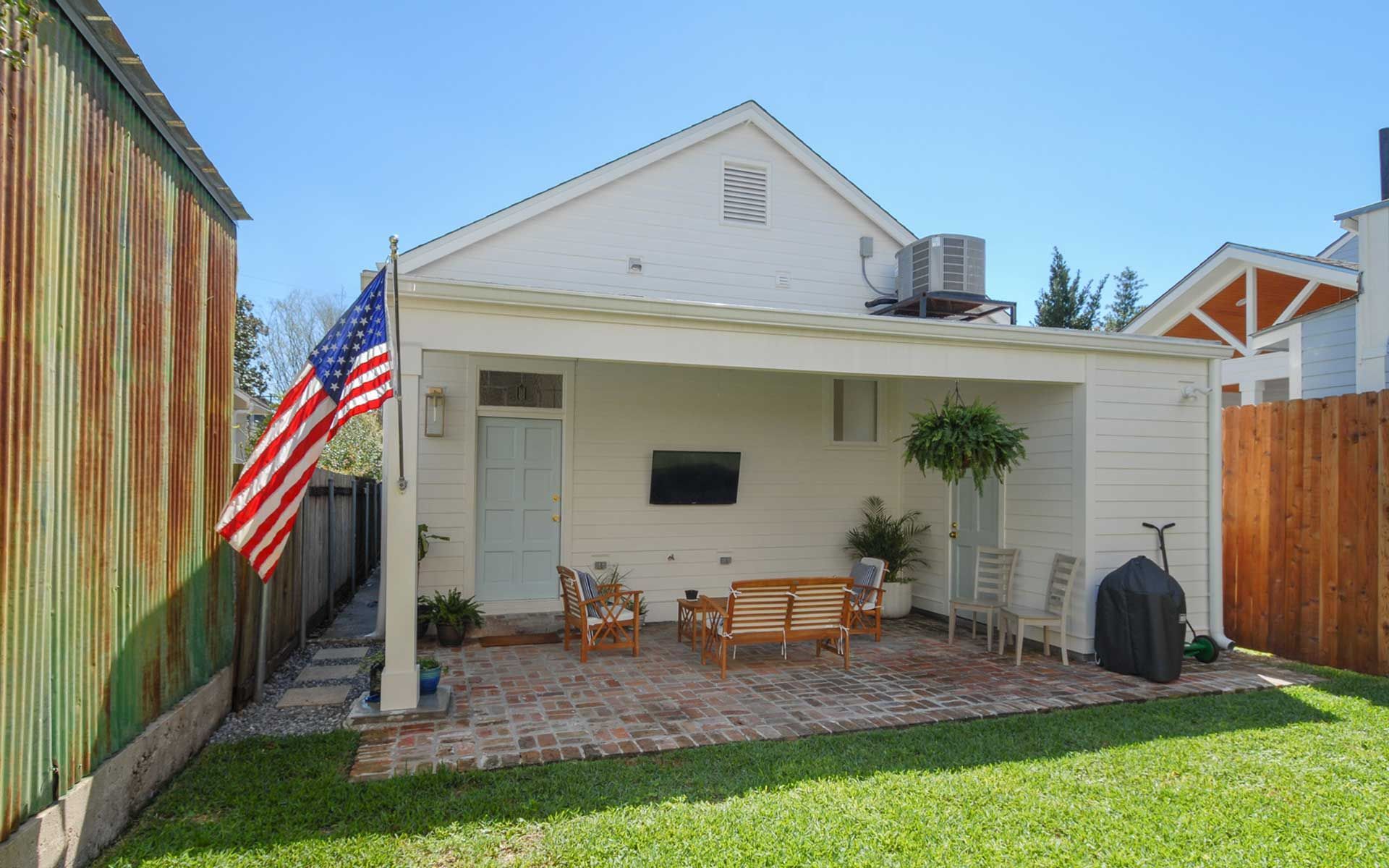 A large american flag is flying in front of a white house
