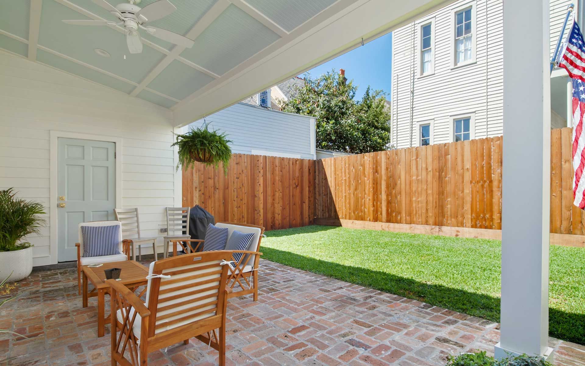 A patio with chairs , a table and a ceiling fan.