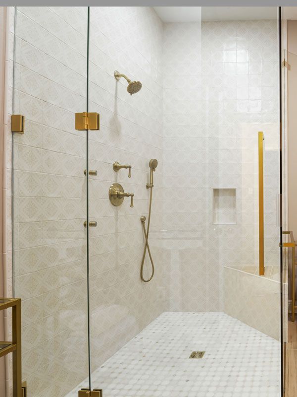 A bathroom with a walk in shower with a glass door