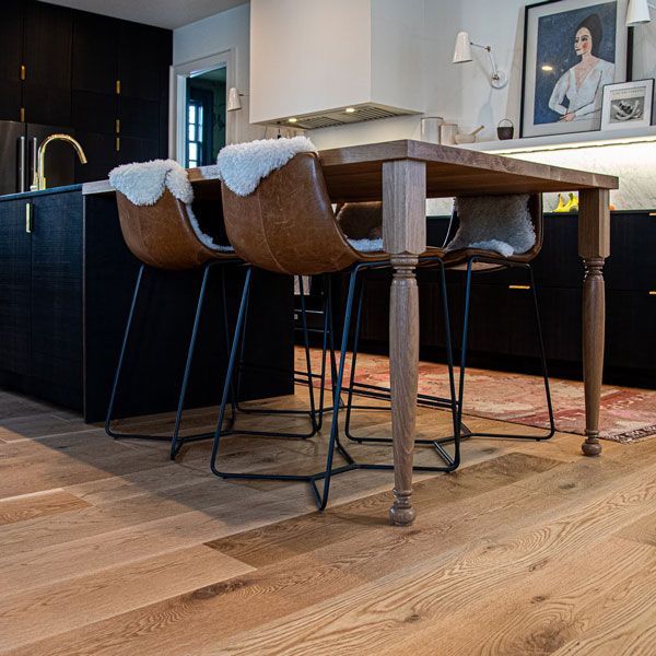 A kitchen with a wooden table and chairs in it.