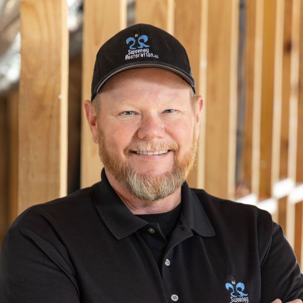 A woman in a black sweater is holding an orange folder