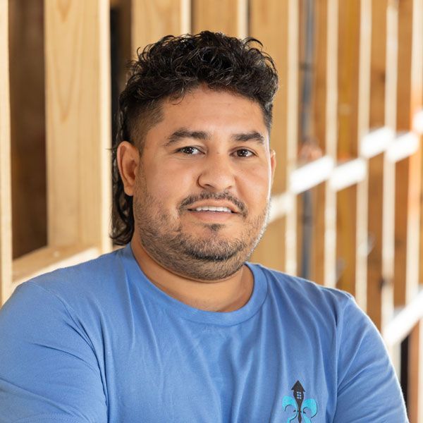 A woman is smiling and wearing a green and white shirt.