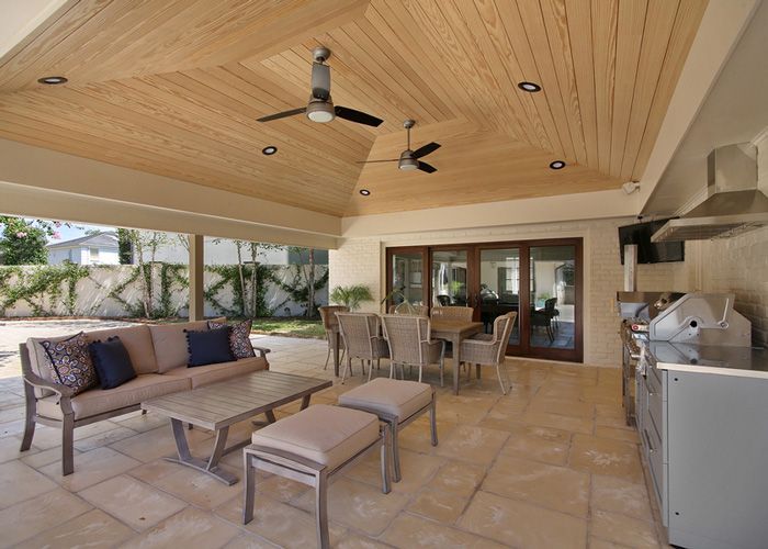A patio with a ceiling fan and a table and chairs