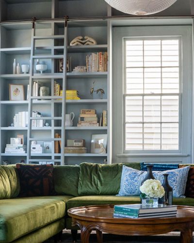 A living room with a green couch and a round coffee table