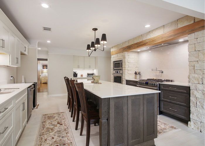 A kitchen with a large island and chairs in it.