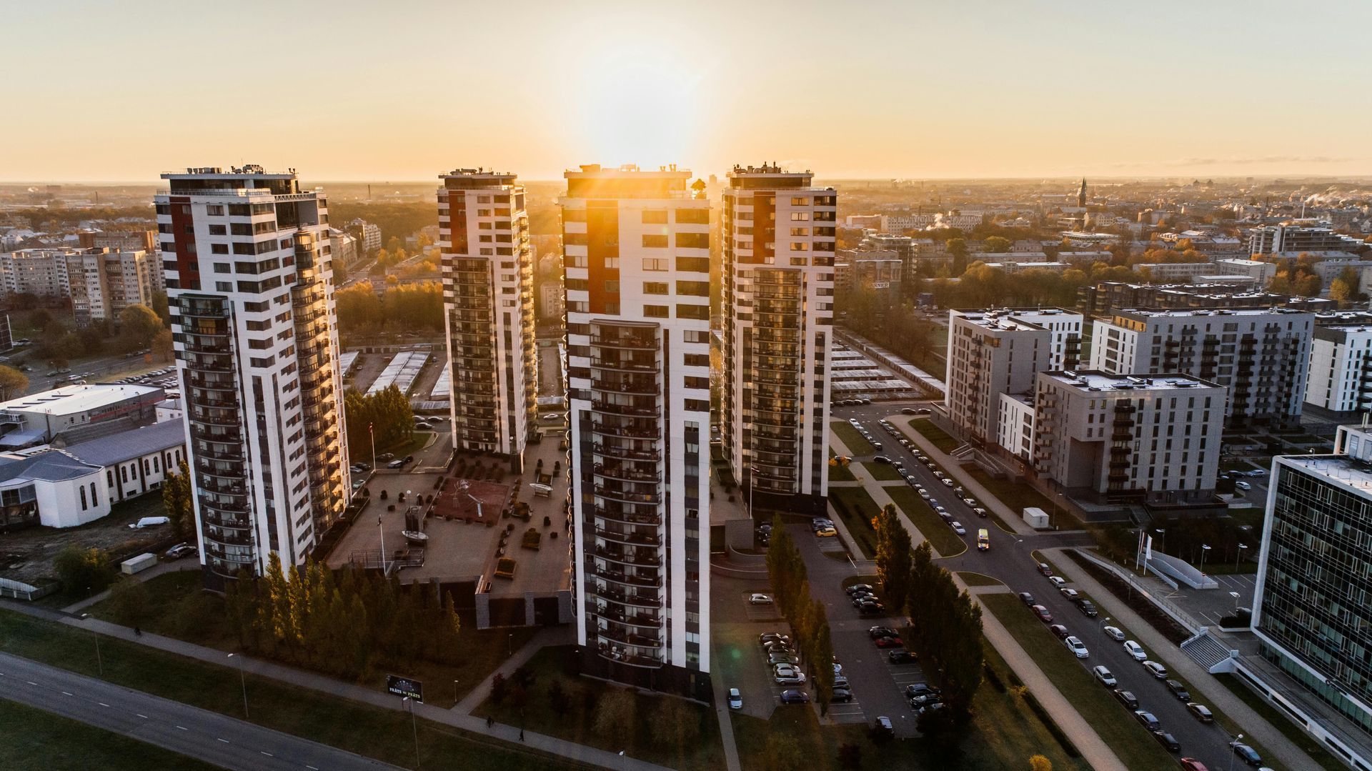 An aerial view of a city with tall buildings at sunset.