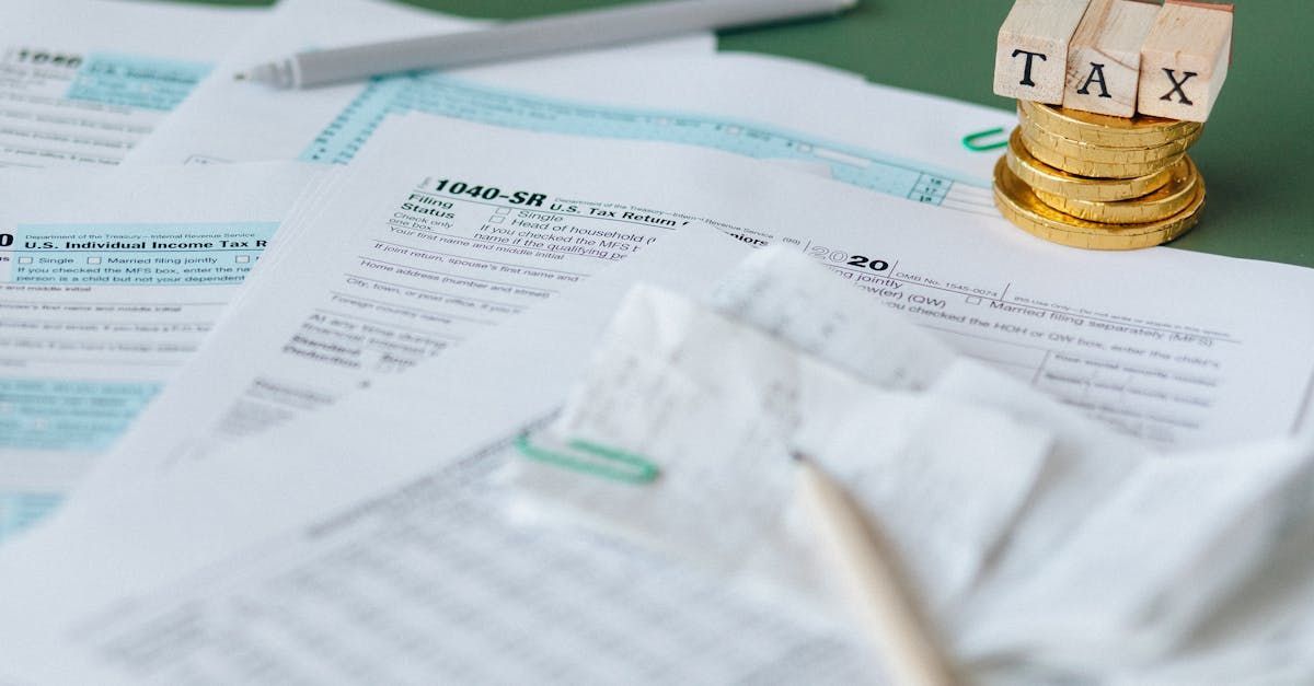 A piece of wood with the word tax on it is sitting on top of a pile of papers.