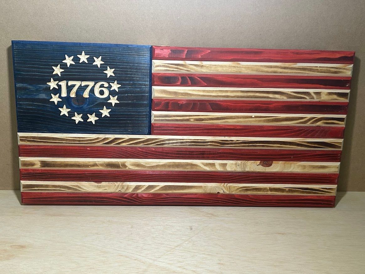 Wooden American flag with stars, 1776, and red/blue/white stripes.