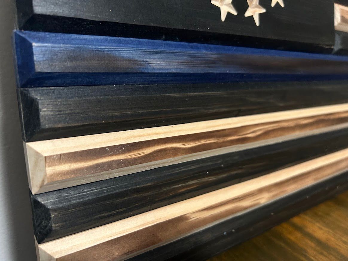 Wooden American flag art with a blue stripe, stars, and stripes.