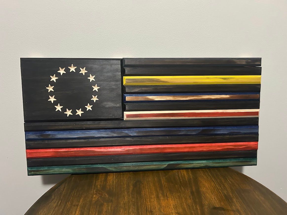 Wooden American flag artwork with colored stripes, and a circle of stars on a black field.