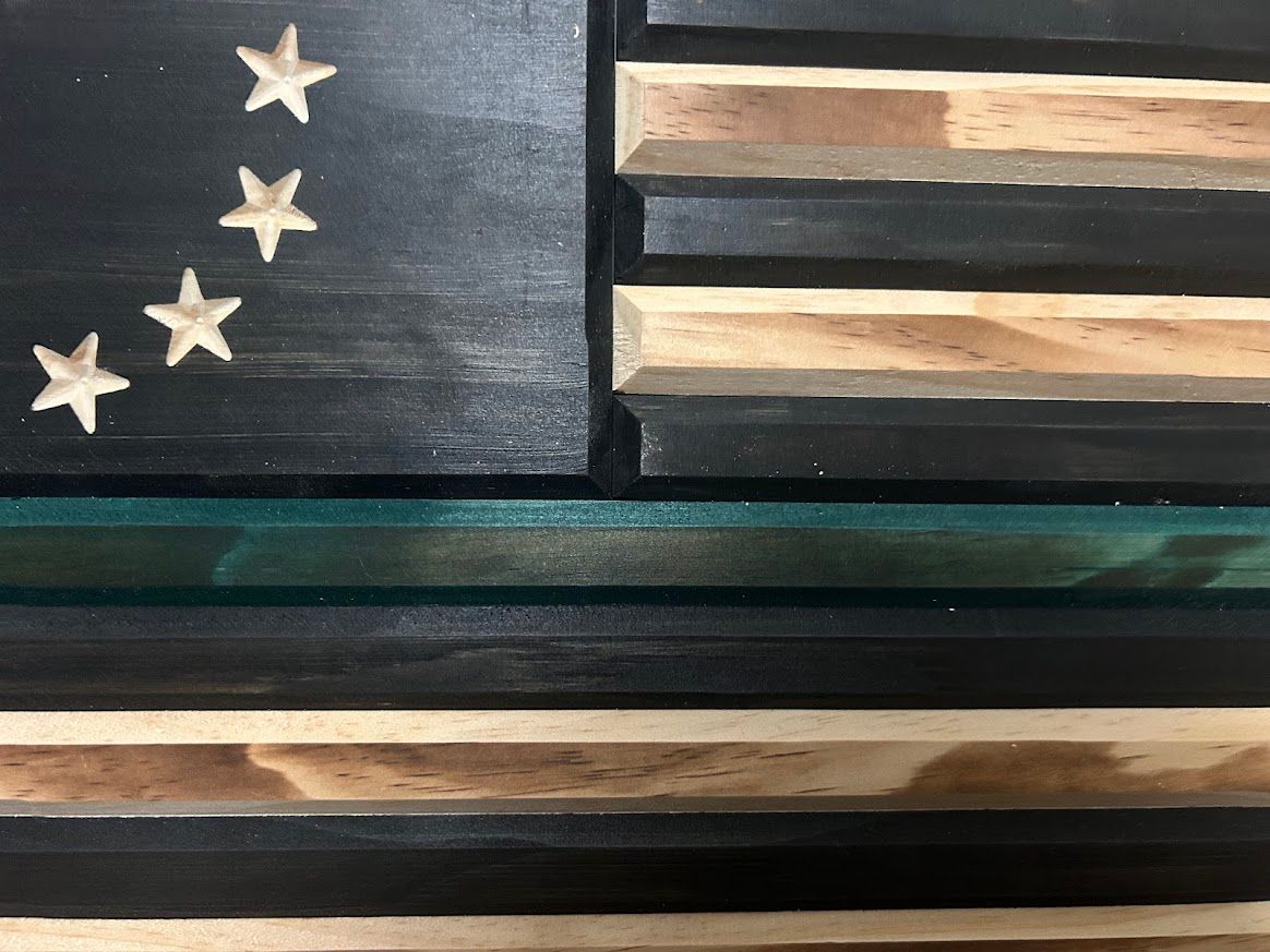 Wooden thin green line flag with 13 stars in a circle.