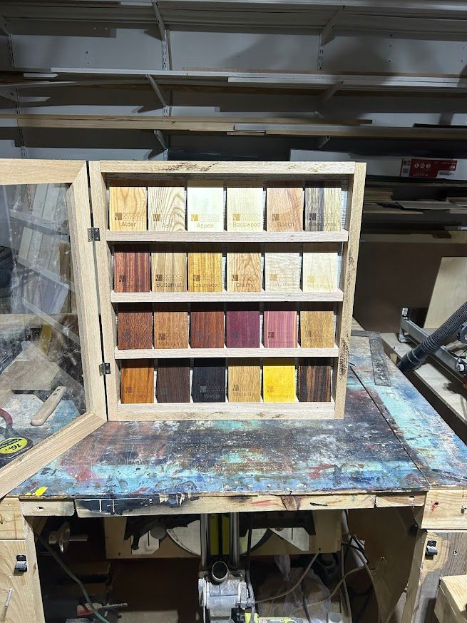 Wooden cabinet displaying various wood samples on a workbench.