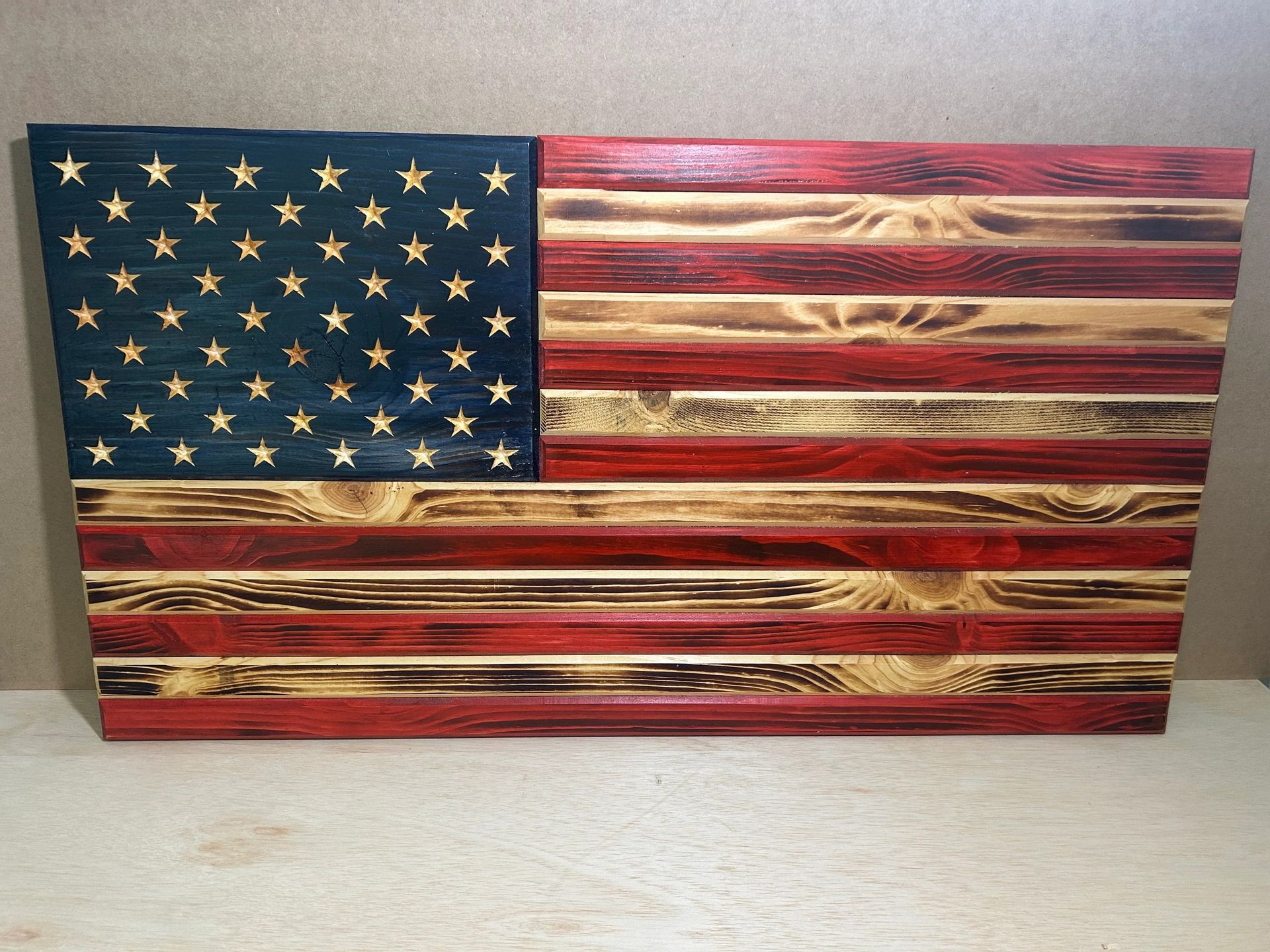 Wooden American flag, stars on blue field, red and natural wood stripes.