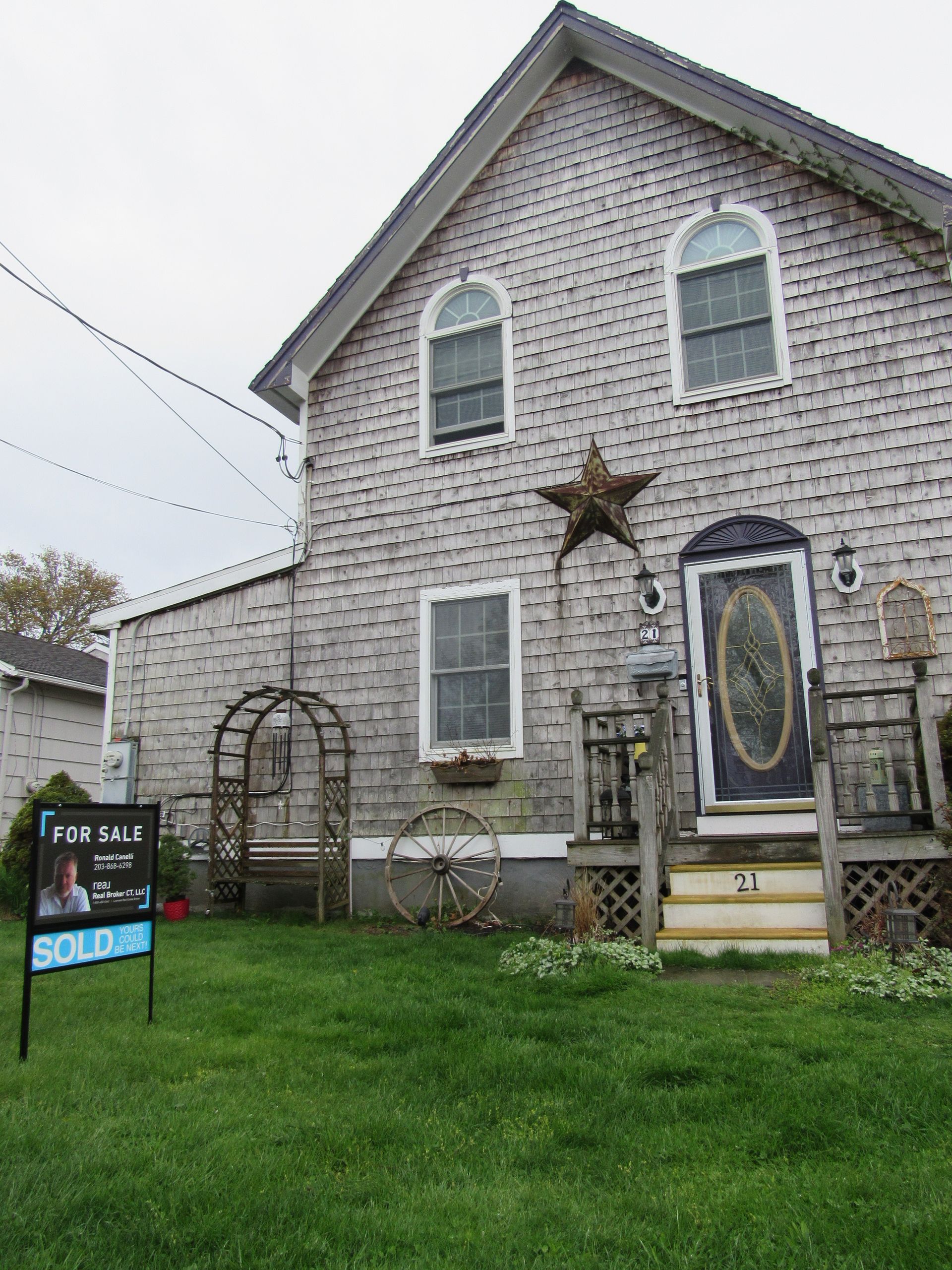 Two-story house with gray shingles, arched windows, and a 