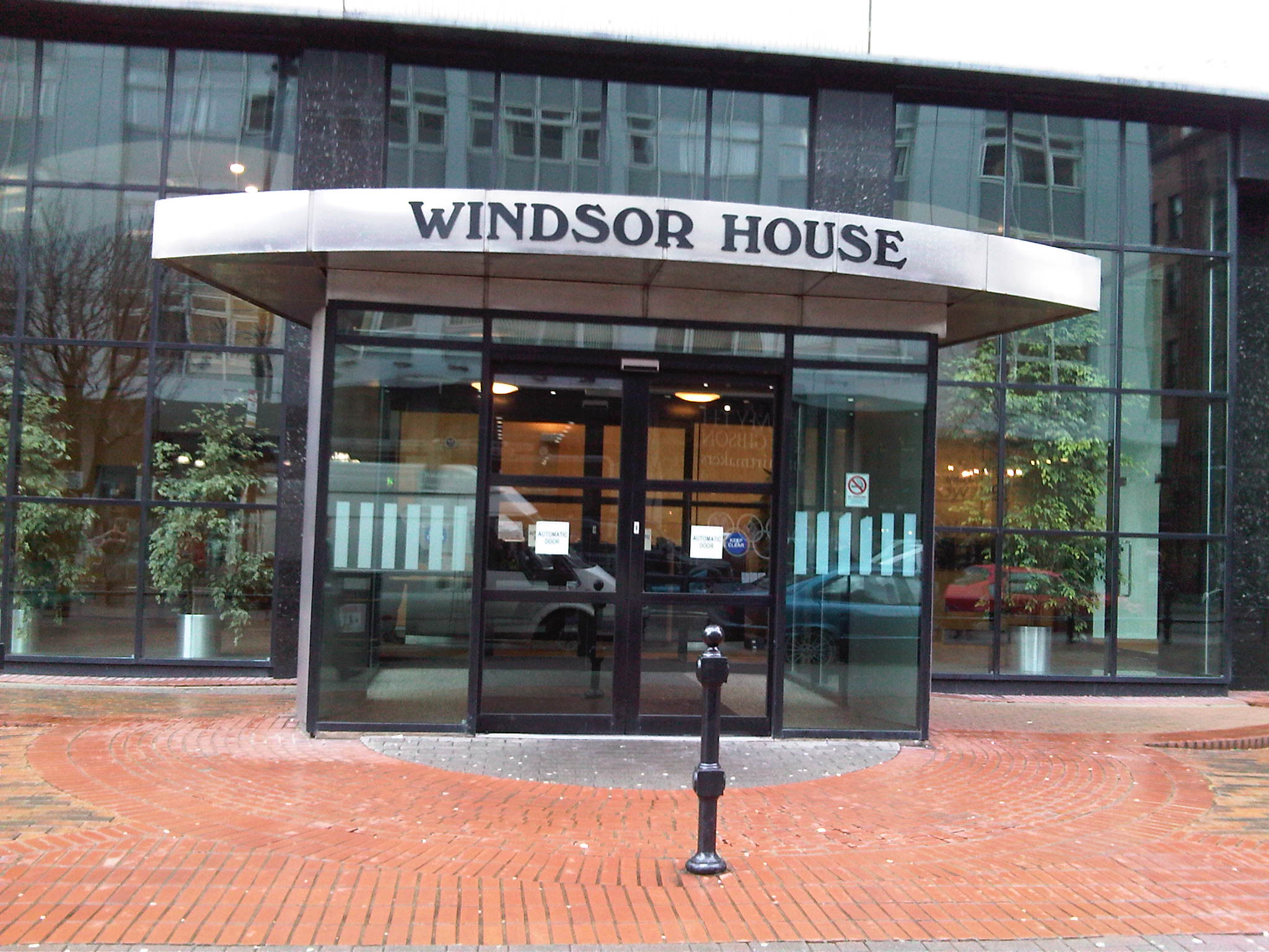 Windsor House entrance: glass doors, awning, brick walkway.