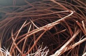 A tangle of discarded, thin copper wires with a brownish-red metallic luster.