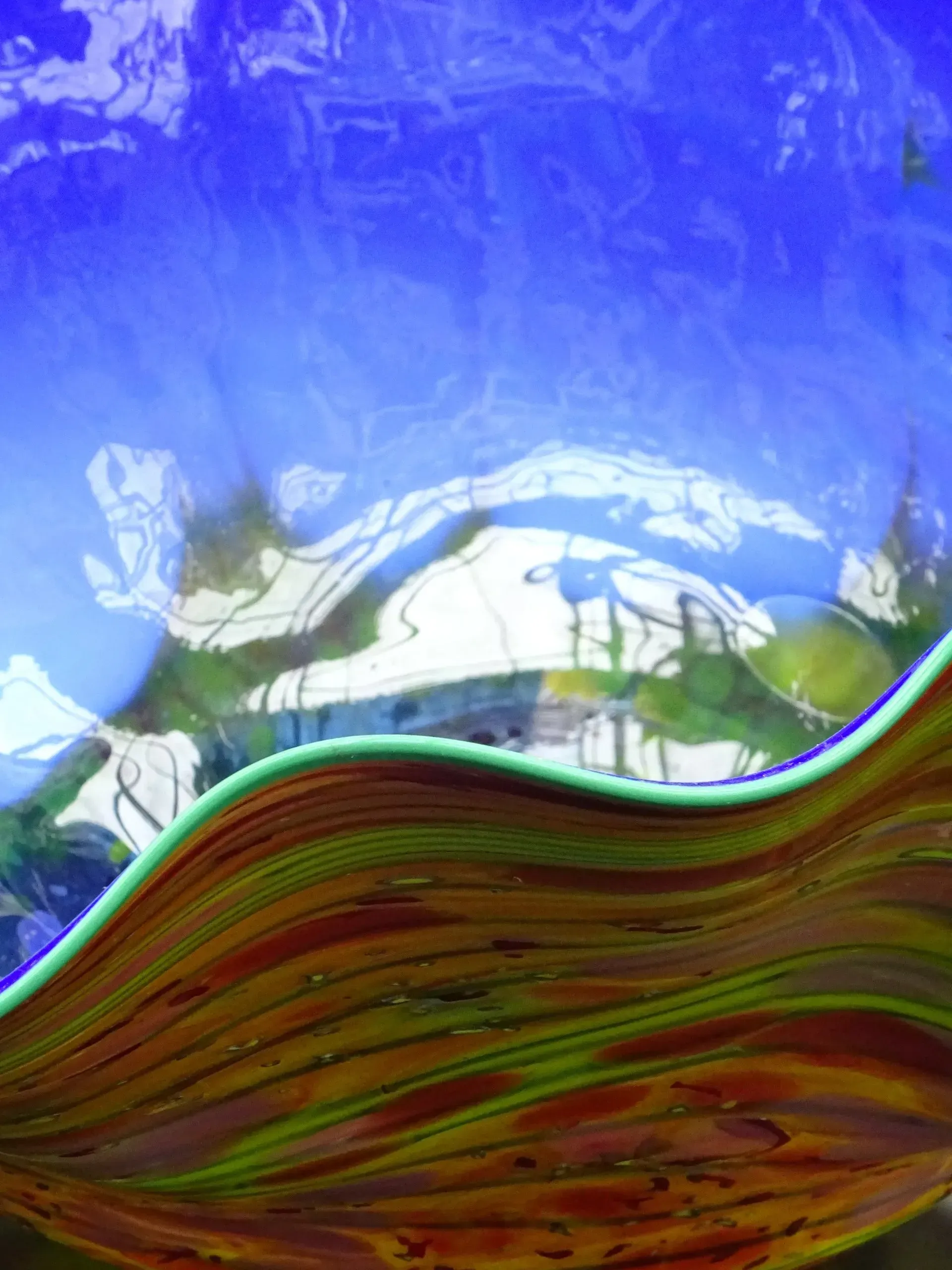 Debbie Nuttall Artist | a close up of a colorful glass bowl with a blue background