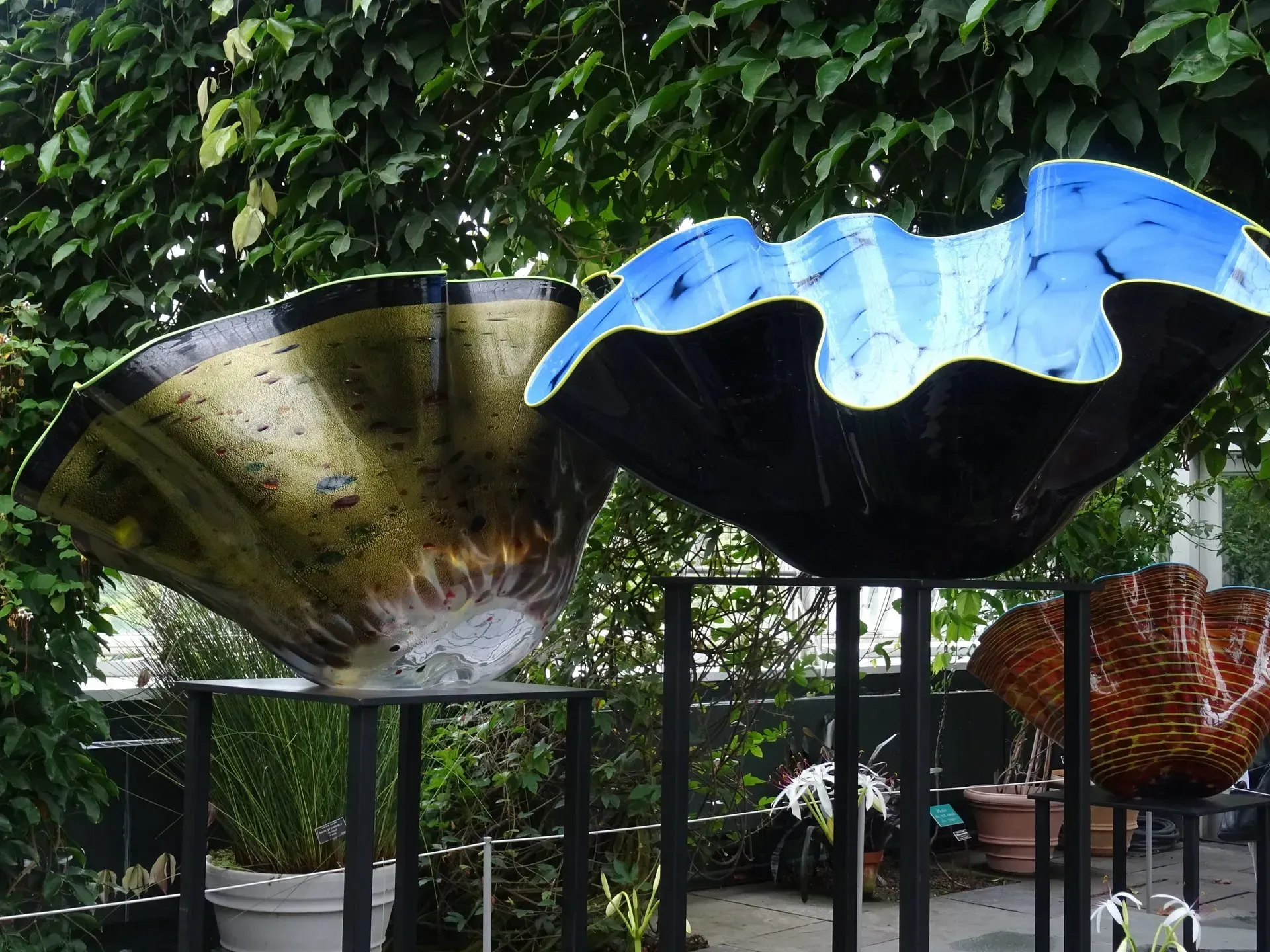 Debbie Nuttall Artist | two sculptures are displayed in a garden with trees in the background