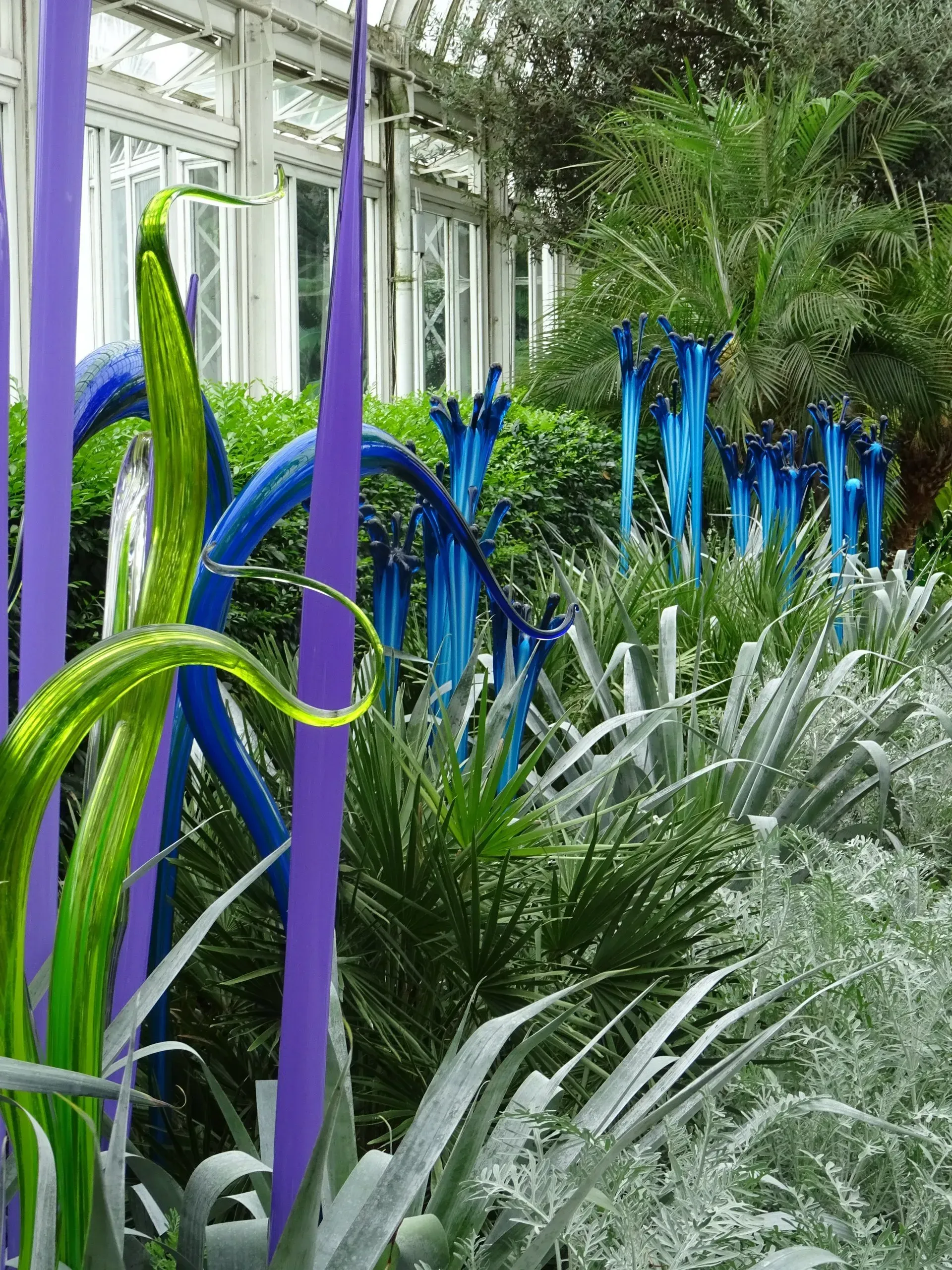 Debbie Nuttall Artist | a garden with purple and green glass sculptures
