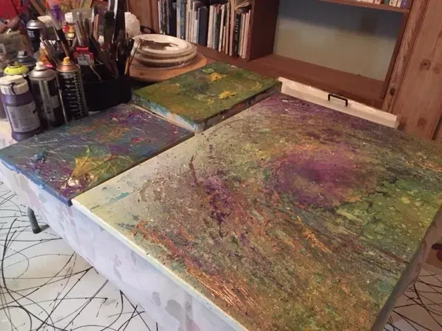 Debbie Nuttall Artist | a can of acrylic paint sits on a table next to two paintings