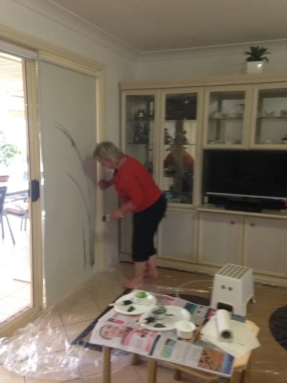 Debbie Nuttall Artist | a woman is painting a wall in a living room