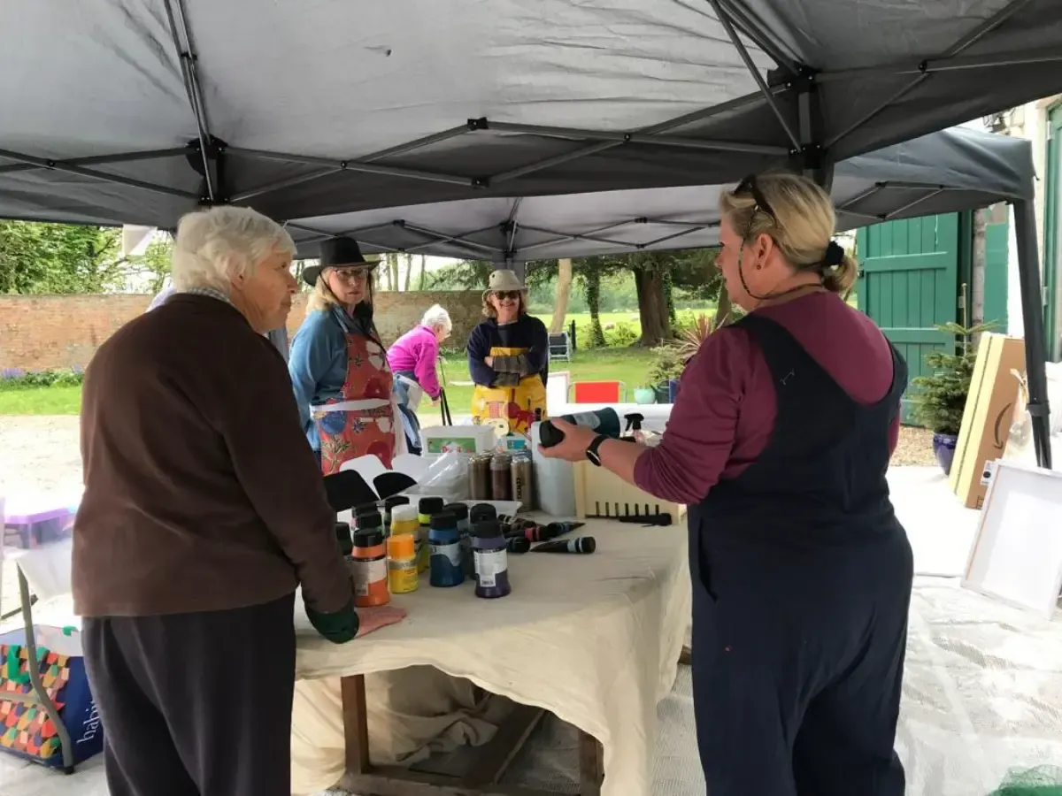 Debbie Nuttall Artist Abstract Workshop | a group of women standing around a table with bottles of acrylic paint