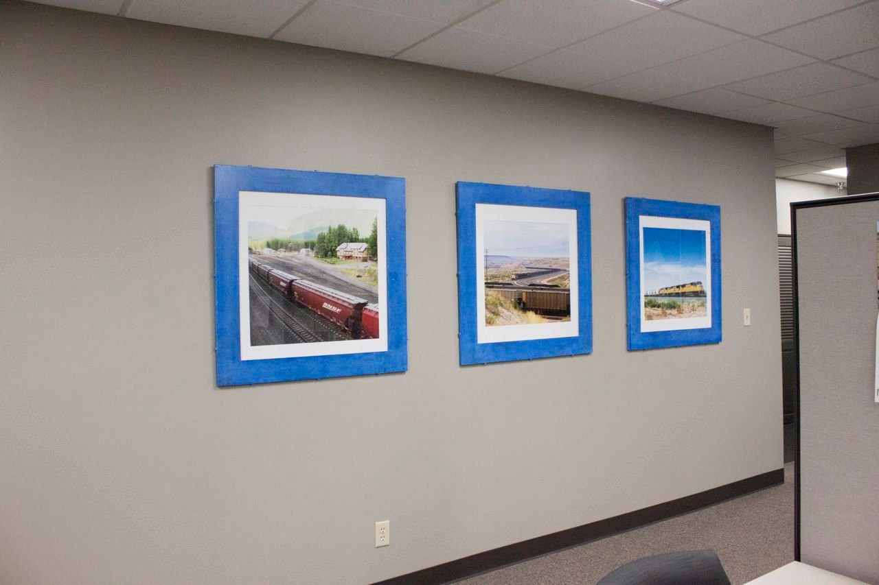 Three pictures are hanging on a wall in a room.