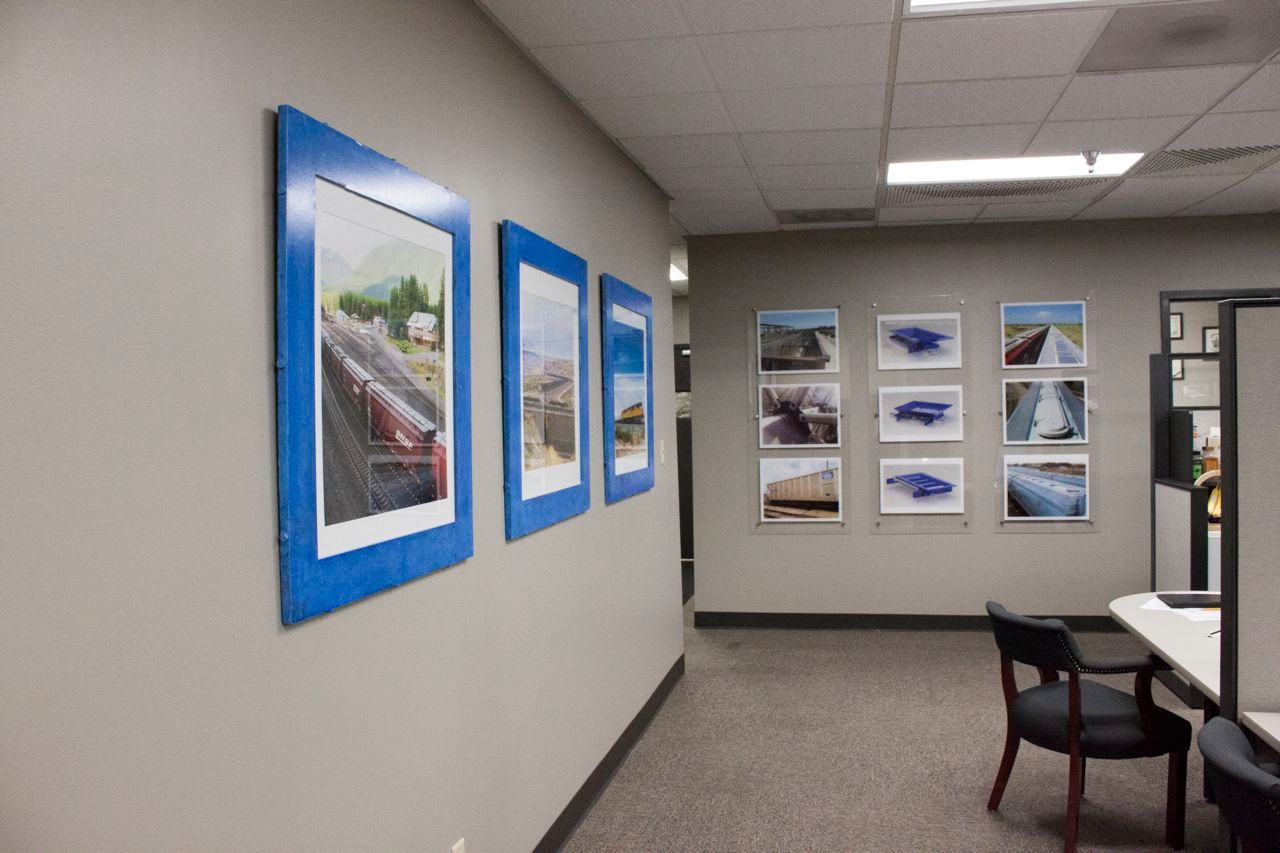 A hallway with pictures on the wall and a table and chairs.