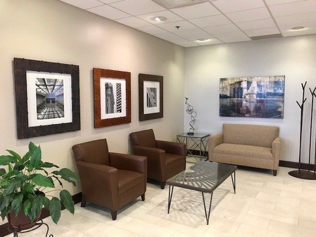 A waiting room with chairs , a couch and a coffee table.