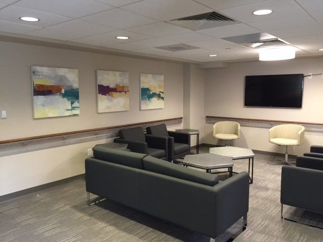 A living room with a couch and chairs and a flat screen tv