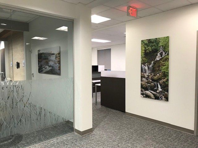 A hallway with a picture of a waterfall on the wall.