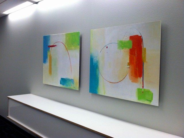 Two colorful paintings are hanging on a wall