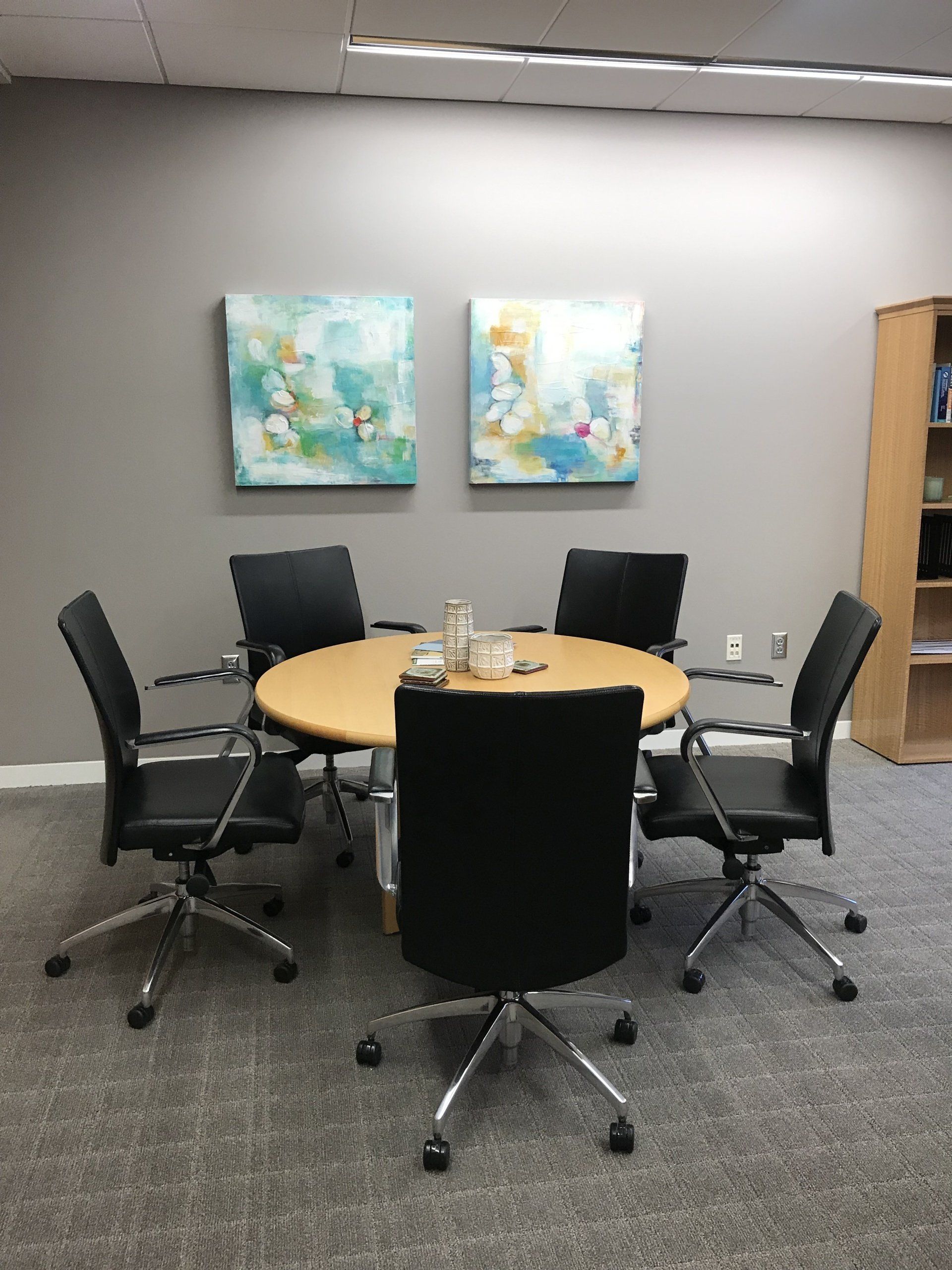 A conference room with a round table and chairs