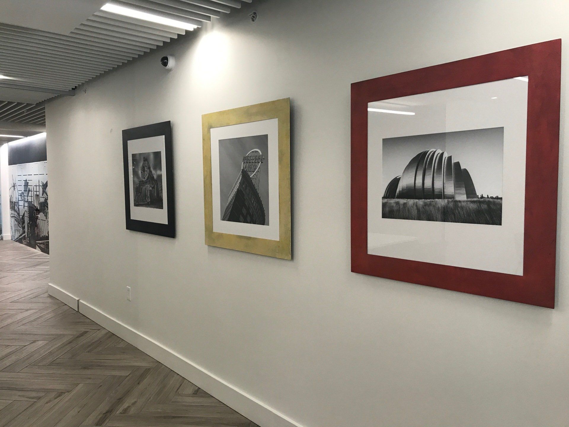 A hallway with three framed pictures on the wall.